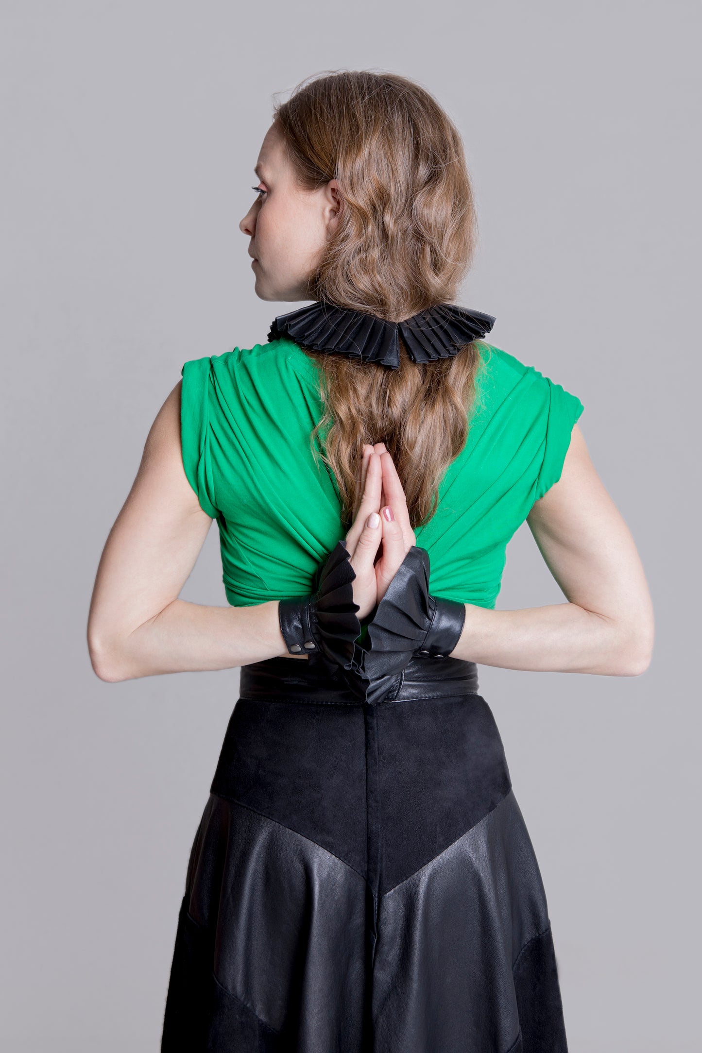 Denduon leather cuffs black on woman in green shirt and black leather skirt