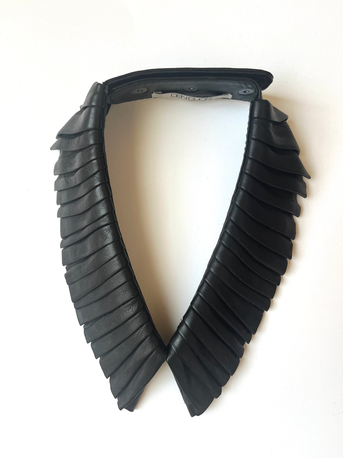 Denduon pleated black leather collar on white background