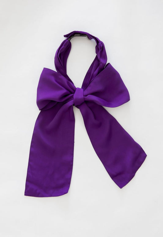 A purple textile bow with snapbuttons in back neck, placed on a white background.